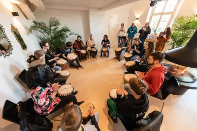 Účastníci hrají na djembe při firemní akci