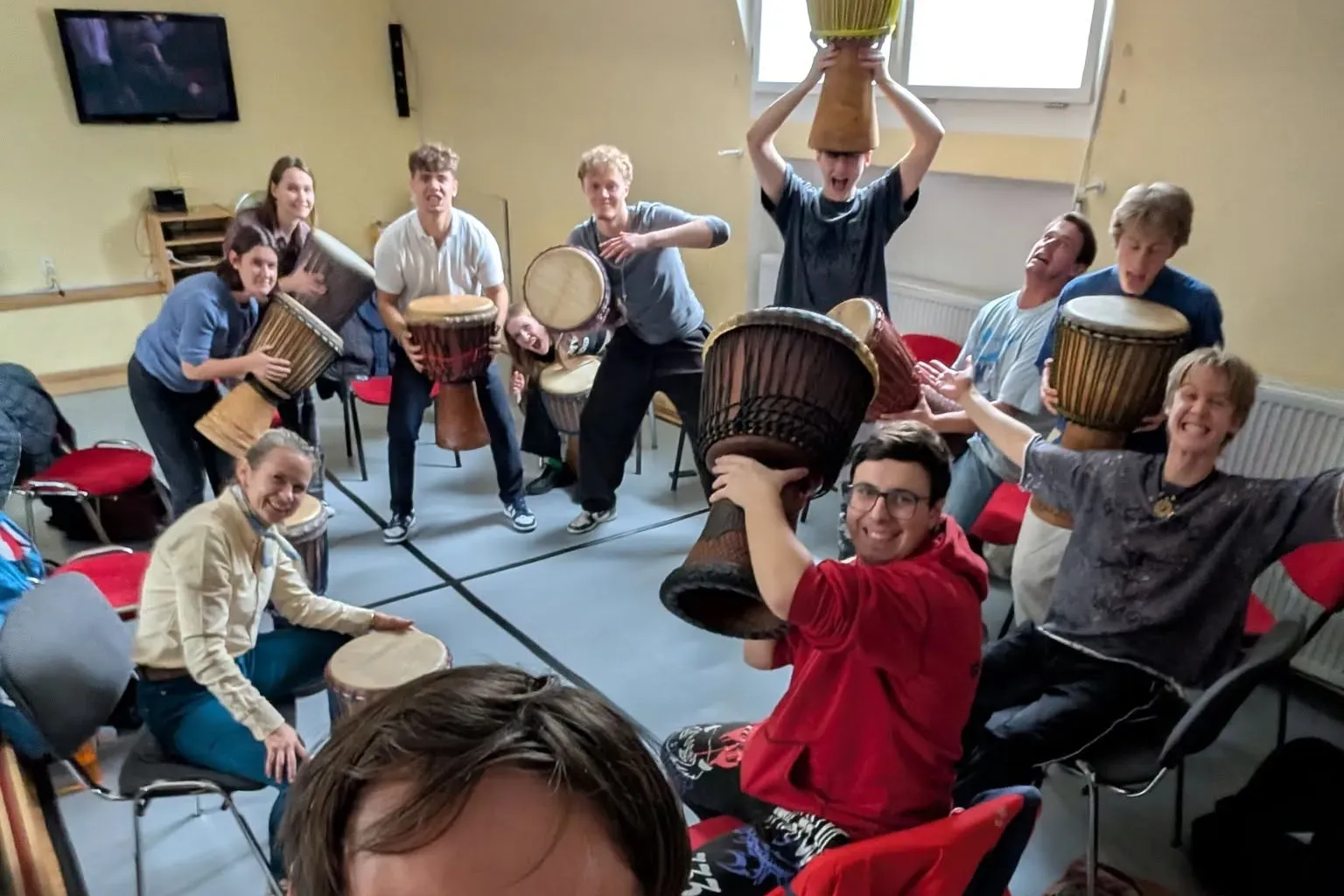 Účastníci workshopu se zdviženými bubny djembe